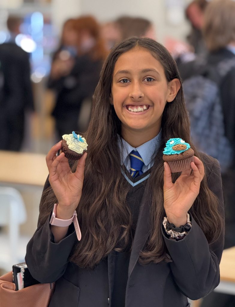 A student holding cakes at Bishop Perowne
